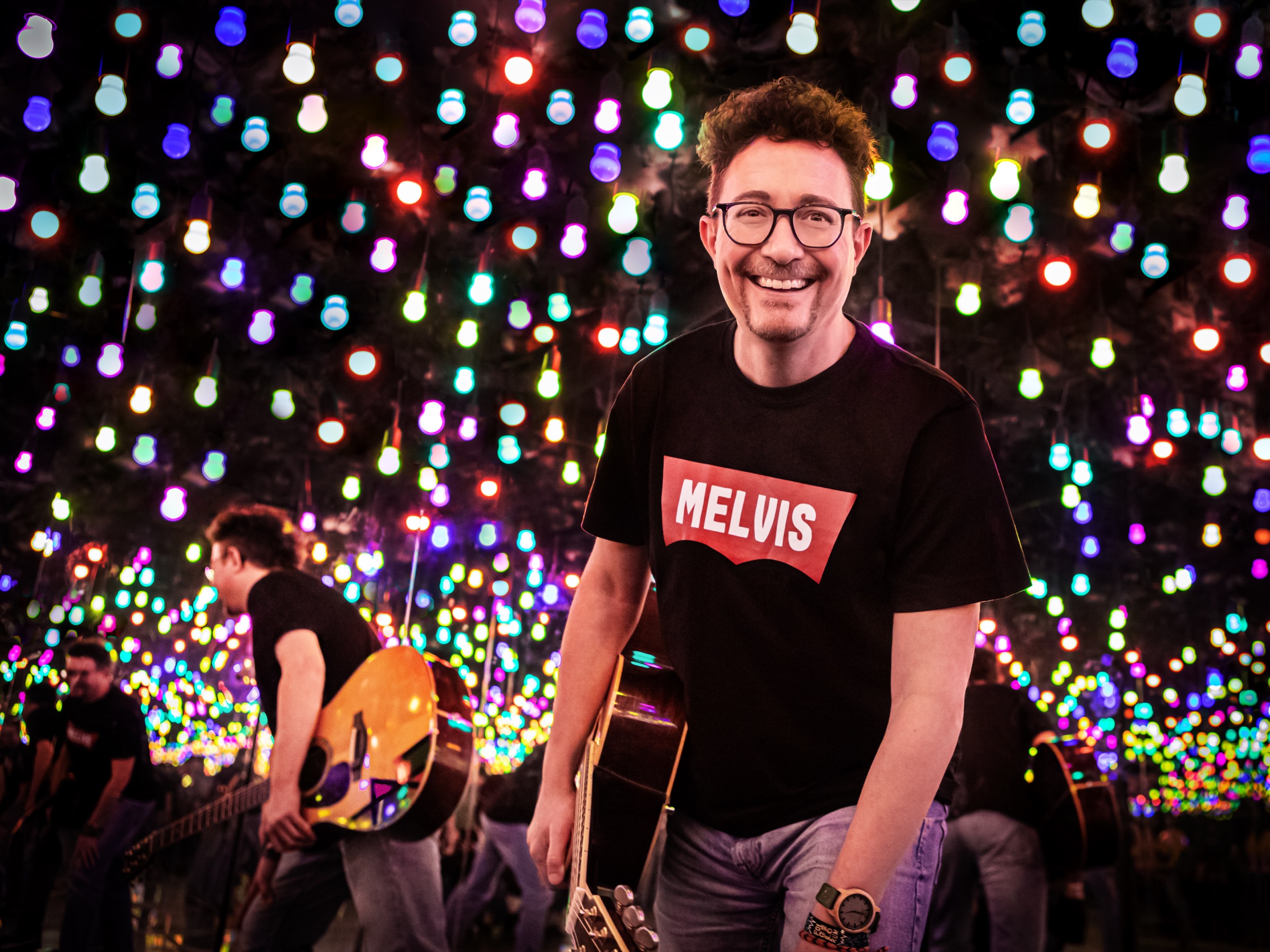 Melvin Haack mit Gitarre in einem Raum voller bunter Glühbirnen